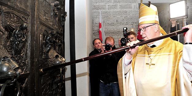 Bischof Norbert Trelle klopft an die Bernwardtür zu Beginn des Festgottesdienstes der Wiedereröffnung des Hildesheimer Domes, im Hintergrund Michael Hammers - Bild: Bischöfliche Pressestelle Hildesheim