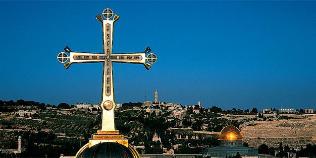 Das Golgothakreuz der Grabeskirche in Jerusalem mit dem Felsendom im Hintergrund. Foto: Markus Bollen